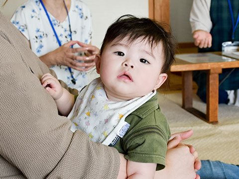 ママに抱っこされる赤ちゃんの写真