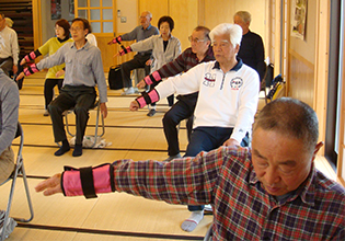 手首におもりをつけて腕を上げている様子