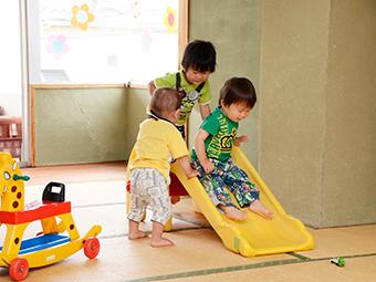 おもちゃの滑り台で遊ぶ子どもたち