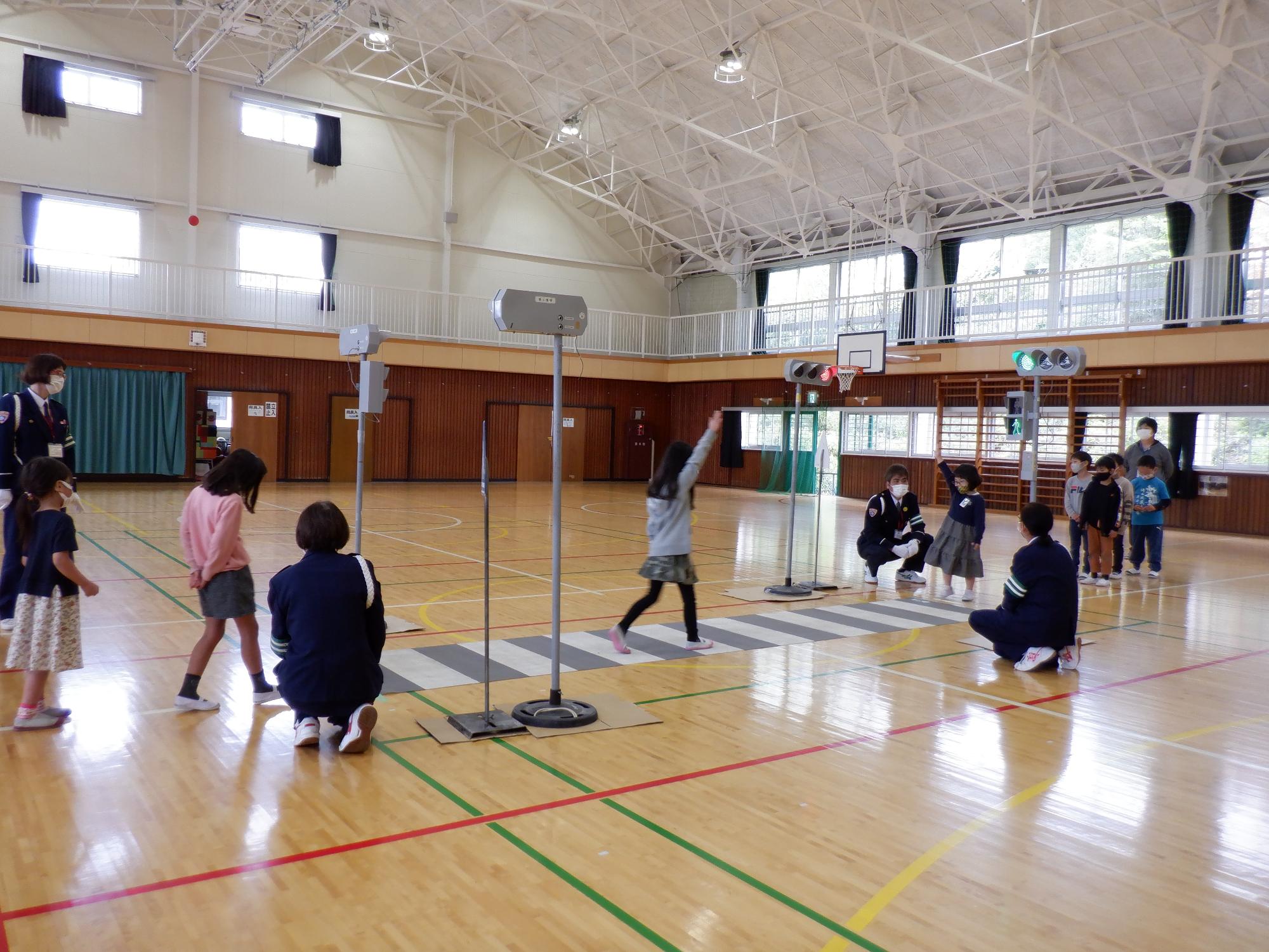 横断歩道を大きく右手を挙げてわたる練習をする子どもたちの写真