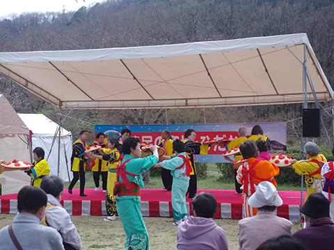 ステージで踊りを披露する皆さんをみている人たち