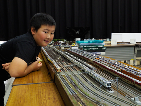 走る鉄道模型を嬉しそうに見る子ども