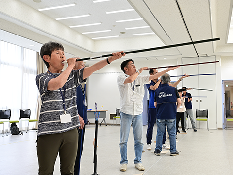 横一列になり、的を狙う参加者たち