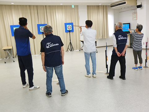 講師の指導の基、的を狙う参加者たち