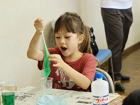 自分で作っているスライムに触れ、喜んでいる子ども