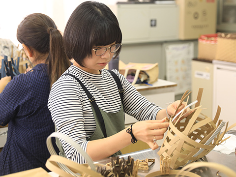 薄い木材を編み込んでいる参加者
