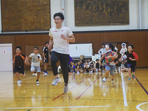 城西大学陸上競技部の人と競争する子どもたち