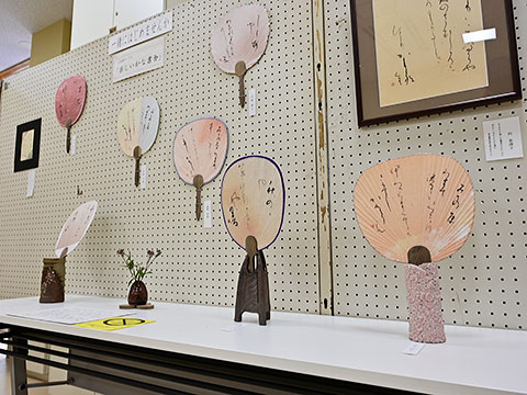 毛筆でさまざまな文などを書き込んだうちわの展示
