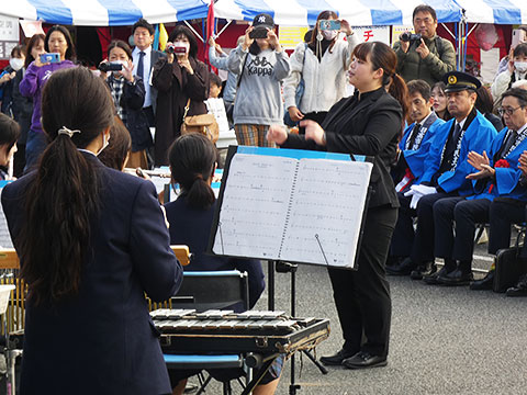 開会式で演奏する中学生と指揮者の先生