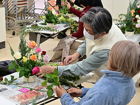 花の配置を調整する参加者と講師