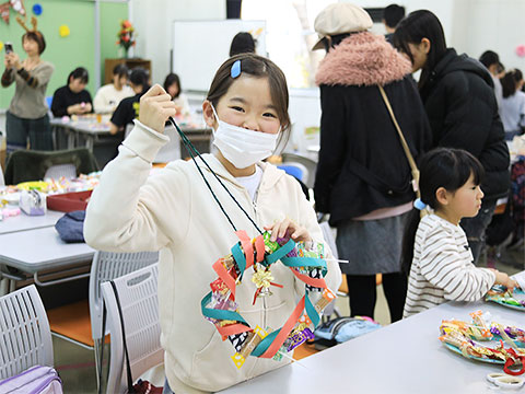 クリスマス飾りを手に持ち笑顔を見せる子ども