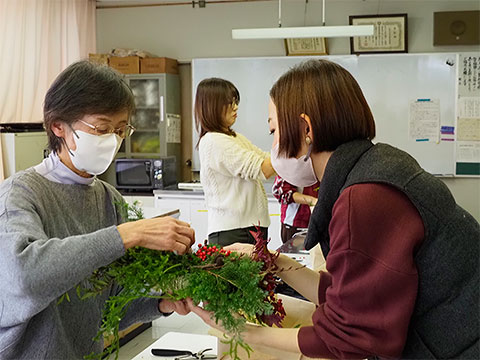 協力して飾り付けをする参加者と講師