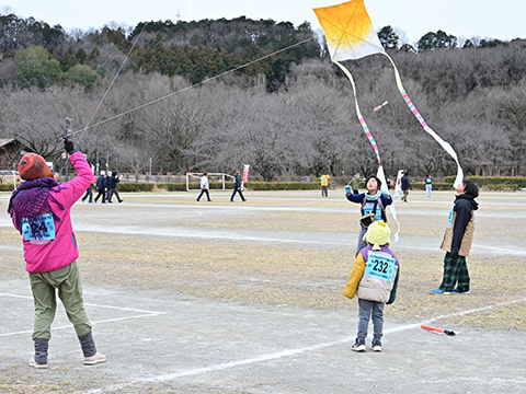 協力してたこを揚げている親子