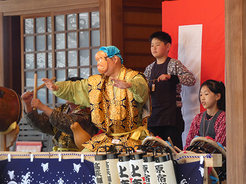 おはやしを踊るひょっとこの面を付けた男性