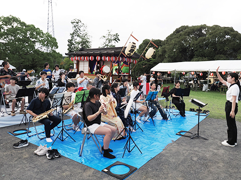 山車を背に演奏をする武蔵台小中学校吹奏楽部の生徒たち