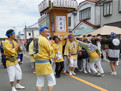山車を担ぎ道路を進む参加者たち